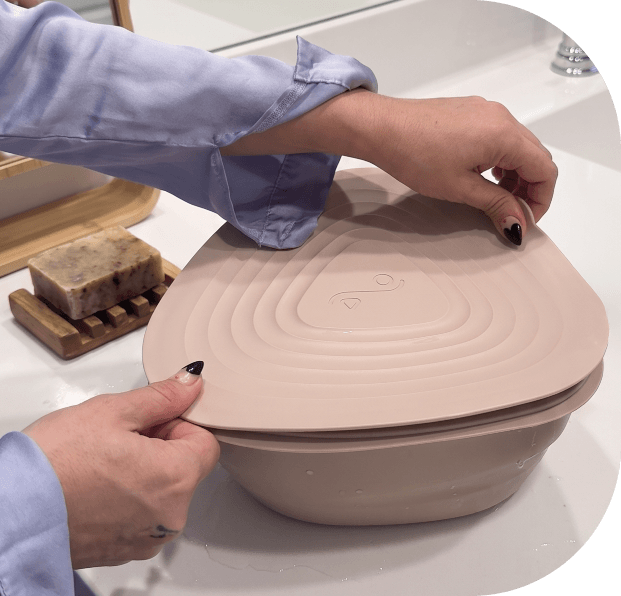 | Icelift Person sealing a beige collapsible silicone bowl with its lid in a kitchen