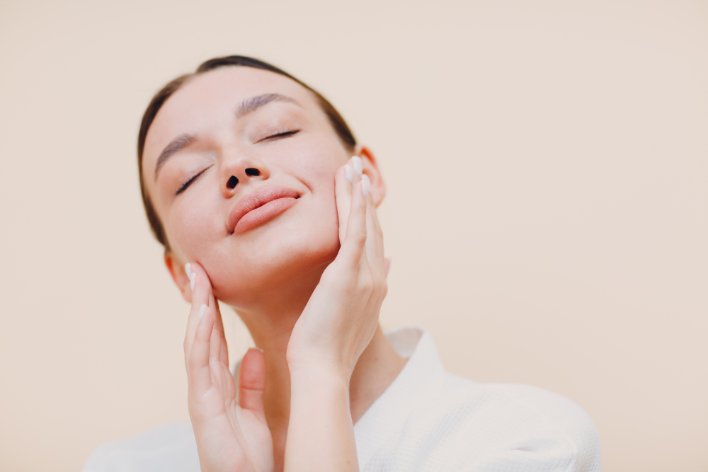 Close up of a woman massaging her face with both hands eyes closed during a skincare routine on a soft beige backdrop |OopsOops I need multiple options in array format Lets correct Use plain array of strings without stray punctuation