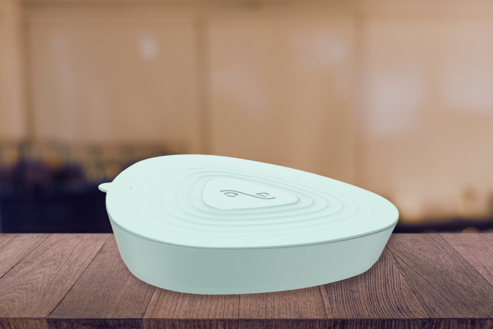 Should You Ice Your Face After a Hot Shower2 | Icelift Mint green heart shaped wireless charger resting on a wooden table with a blurred background conveying a tech accessory
